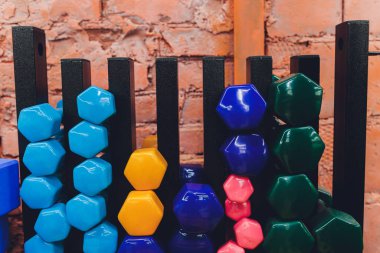basık satır odak için satır üçüncü ve dördüncü dumbbells ile istemciler için bekleyen bir spor salonunda dizilmiş ağırlıkları.