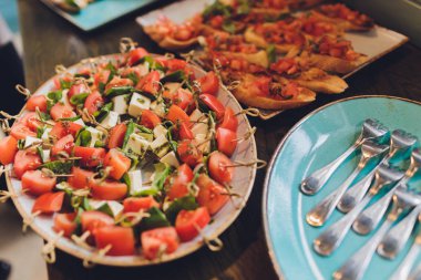 Atıştırmalık kanepeler kızarmış ekmek domates maydanoz ve salam hizmet ile close-up büyük tabak.
