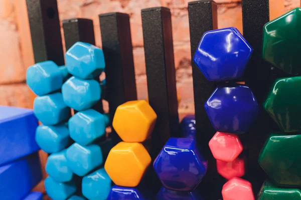 Receding row of weights lined up in a gym waiting for clients with focus to the third and fourth dumbbells in the row. — Stock Photo, Image