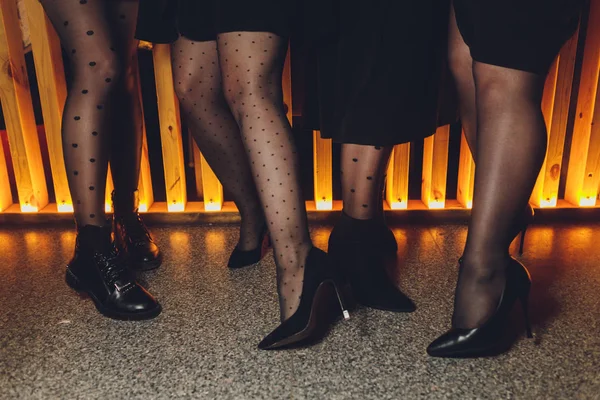 Mooie vrouwelijke benen in zwarte panty in een restaurant. — Stockfoto