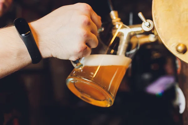 Close-up de mão barman na torneira de cerveja derramando uma cerveja lager calado . — Fotografia de Stock