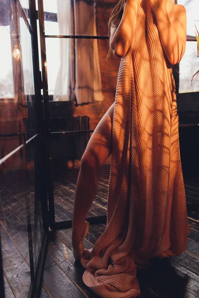 Вид ззаду красива молода жінка знімає халат, стоячи з оголеною спиною у ванній кімнаті . — стокове фото