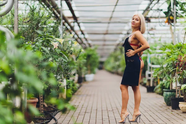 Pretty young woman gardening in an apron, without clothes. — 图库照片