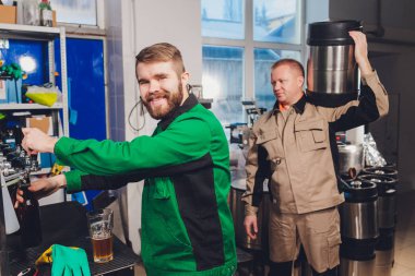 Bira fabrikası taşıyıcı hatlarda cam şişelere bira döküyor. Endüstriyel işler, otomatikleştirilmiş yiyecek ve içecek üretimi. Fabrikada teknolojik işler..