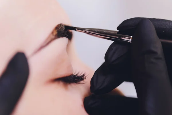 Vacker-makeup artist tillämpa måla henna på tidigare plockade, design, trimmade ögonbryn i en skönhetssalong i sessionen korrigering. Professionell ansiktsvård. — Stockfoto