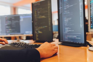 Programcı El Klavyede daha hızlı yazıyor. Programcı kodlama programı ve web sitesi bilgisayar ve ekranla ahşap masaya kondu. Klasik ton biçimi.