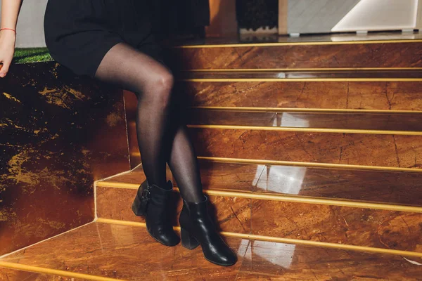 Hermosas piernas femeninas en pantimedias negras en un restaurante . —  Fotos de Stock