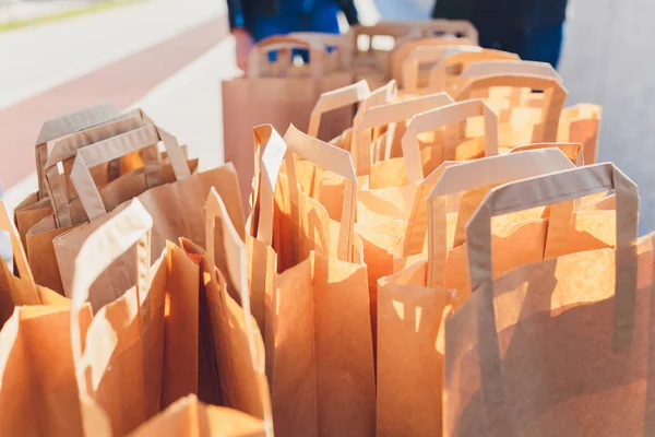 Close up brown clear empty blank craft paper bag for takeaway isolated on pastel pink background. Packaging template mock up. Delivery service concept Copy space advertising area.