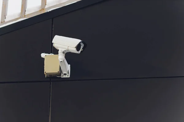 Kamera bezpieczeństwa na ciemnym nowoczesnym budynku, koncepcja technologii. — Zdjęcie stockowe