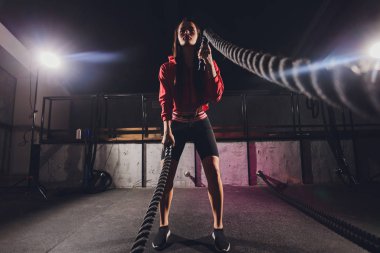 Atletik genç bayan dışarıda bir iple egzersiz yapıyor..