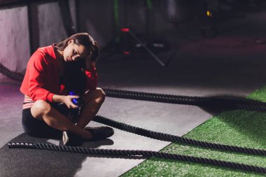 Atletik genç bayan dışarıda bir iple egzersiz yapıyor..