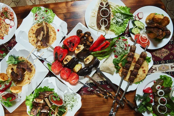 Kebabs de porc maigre en cubes servis avec une tortilla de maïs et une salade de laitue fraîche et de tomates, vue rapprochée sur un fond sombre . — Photo