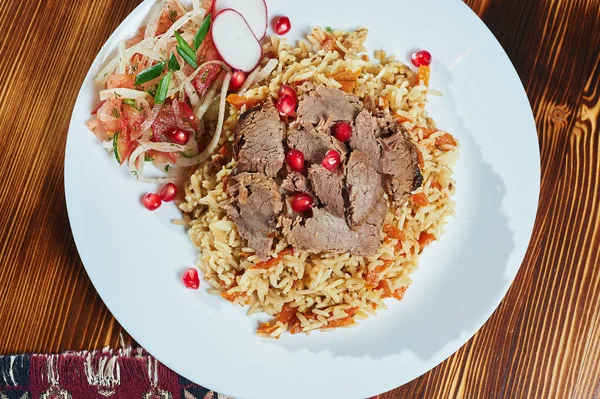 Delicioso pilaf asiático en un plato marrón. vista horizontal desde arriba, estilo rústico . — Foto de Stock