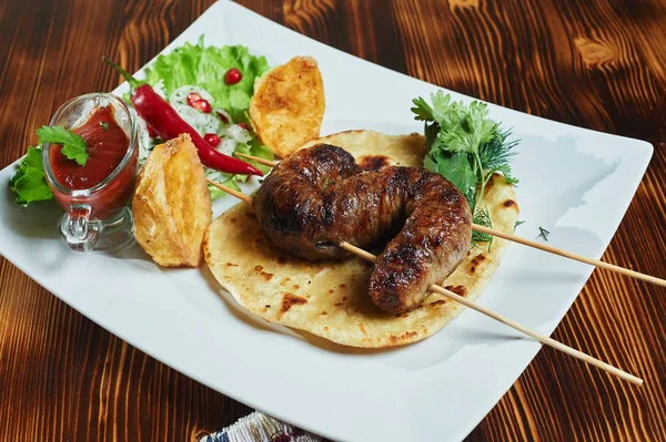 Churrasco saudável kebabs carne de porco cubo magra servido com uma tortilla de milho e alface fresca e salada de tomate, vista de perto em um fundo escuro . — Fotografia de Stock