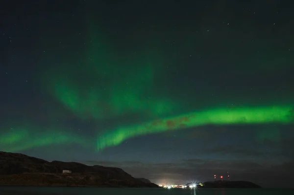 Aurora borealis boven de oceaan. Noorderlicht in Teriberka, Rusland. Sterrenhemel met poollicht en wolken. Nachtelijk winterlandschap met poollicht, zee met stenen in wazig water, besneeuwde bergen. Reizen — Stockfoto