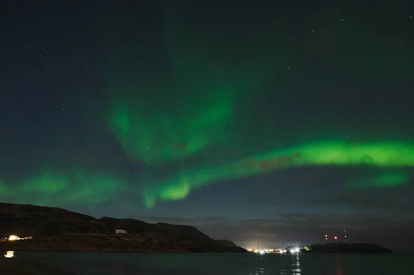 북극광은 바다 위에 있습니다. 북극광은 러시아 테 리베르카에 있습니다. 극광 과 구름 이 있는 별이 빛나는 하늘. 오로라와 함께 한 밤의 풍경, 뿌연 물에 돌 과 눈덮인 산으로 이루어진 바다. 여행 — 스톡 사진