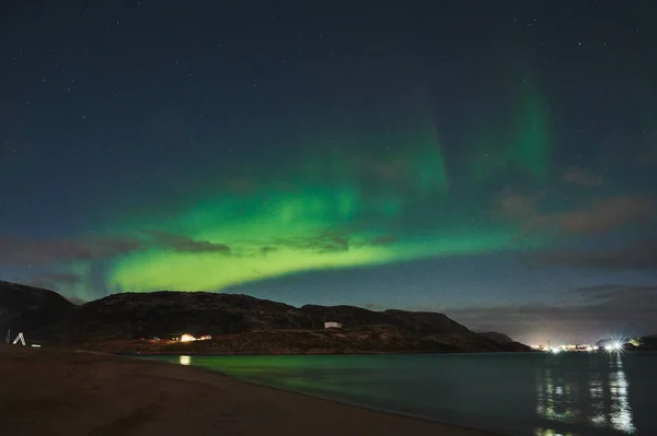 Aurora borealis boven de oceaan. Noorderlicht in Teriberka, Rusland. Sterrenhemel met poollicht en wolken. Nachtelijk winterlandschap met poollicht, zee met stenen in wazig water, besneeuwde bergen. Reizen — Stockfoto