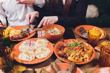 Yukarıdan kahverengi ahşap masa üzerinde Gürcü mutfağı görüntüleyin. Geleneksel Gürcü gıda-Hıngel, kharcho, chahokhbili, phali, lobio ve yerel soslar - tkemali, satsebeli, adzhika. Üstten görünüm. Metin için yer kopyalayın
