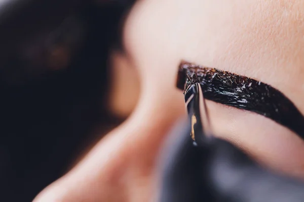 Güzellik makyözü, daha önce koparılmış, dizayn edilmiş, oturum düzeltmesindeki güzellik salonundaki kaşlara boya kına sürmüş. Profesyonel yüz bakımı.