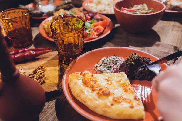 Vista desde arriba de la cocina georgiana en la mesa de madera marrón. Comida tradicional georgiana-khinkali, kharcho, chahokhbili, phali, lobio y salsas locales - tkemali, satsebeli, adzhika.Vista superior.Copiar el espacio para el texto — Foto de Stock