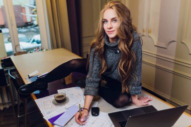 Profesyonel iç mimar ya da tasarımcı renk paleti ile çalışıyor, modern ofiste oda çizimleri yapıyor. Genç bayan model, gelecek daireyi ya da evi planlıyor, renkleri ve tasfiyeyi seçiyor. otururken