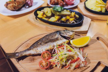 Limon ve vişneli domatesli taze ızgara Dorado. Tüm Bbq Sea Bream Fish Top View ve Flat Lay. Sparus Aurata.