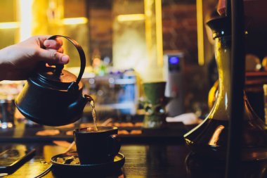Çay çaydanlık closeup üzerinden dökülen eller.