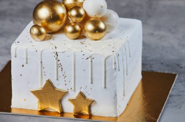 Altın sarısı, bronz toplu ve çikolatalı Noel pastası. Gri renkte izole edilmiş.