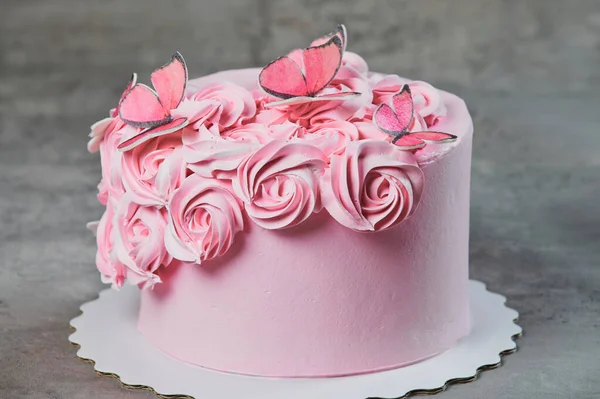 Bovenaanzicht van een vers gebakken cake versierd met roze poedersuiker rozen weergegeven op een taart staan meer dan een zwarte achtergrond met copyspace. — Stockfoto