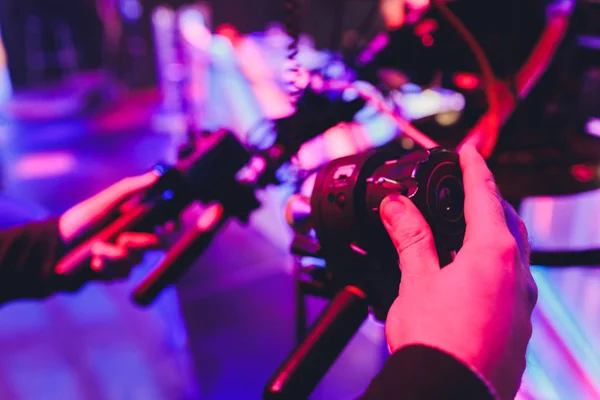 Equipamento profissional em um estúdio de notícias de televisão azul. Dispositivos de iluminação e câmeras de vídeo em um tripé. foco seguir a gestão — Fotografia de Stock