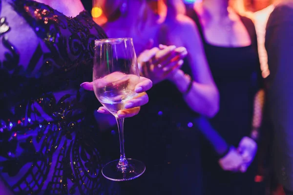 Kobieta ręka z kieliszkiem szampana na tle wakacyjnym. — Zdjęcie stockowe