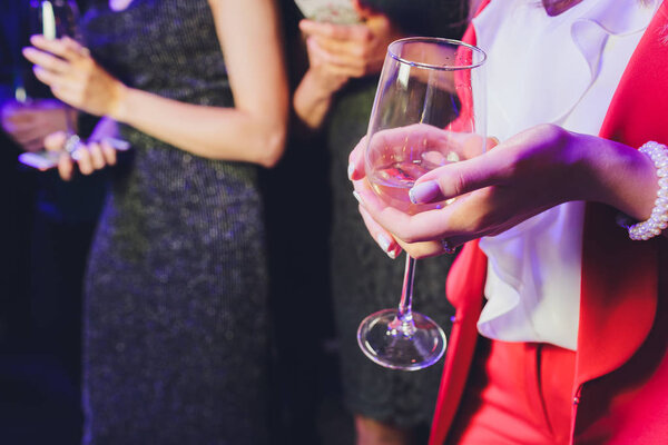 Woman hand with champagne glass on holiday background.