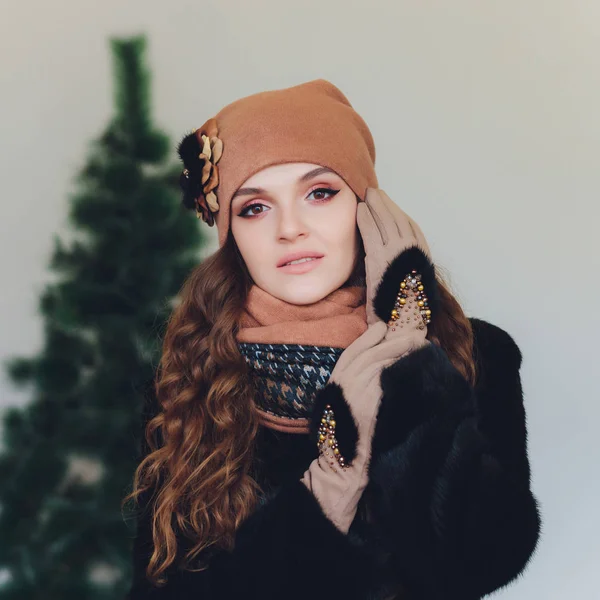 Překvapený šťastná krásná žena vzrušení při pohledu ze strany. Vánoční dívka, která nosí pletené teplé čepice a palčáky, izolované na šedém pozadí. — Stock fotografie