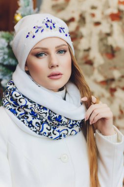 Yana doğru heyecan arayan sürpriz mutlu güzel kadın. Örme sıcak şapka ve gri arka plan üzerinde izole eldivenler giymiş Noel kız.