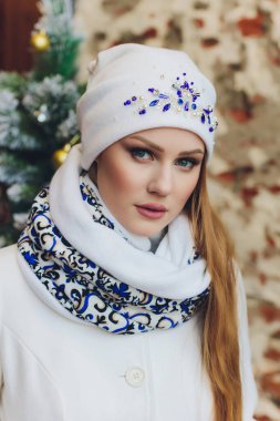 Yana doğru heyecan arayan sürpriz mutlu güzel kadın. Örme sıcak şapka ve gri arka plan üzerinde izole eldivenler giymiş Noel kız.