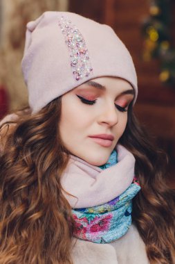 Yana doğru heyecan arayan sürpriz mutlu güzel kadın. Örme sıcak şapka ve gri arka plan üzerinde izole eldivenler giymiş Noel kız.