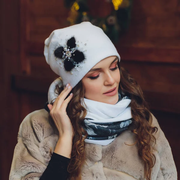 Здивована щаслива красива жінка дивиться в бік хвилювання. Різдвяна дівчина в в'язаному теплому капелюсі і рукавицях, ізольована на сірому фоні . — стокове фото