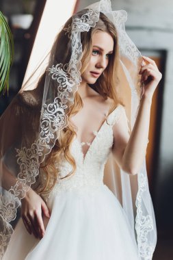 The beautiful woman posing in a wedding dress.