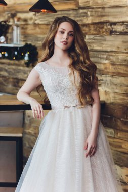The beautiful woman posing in a wedding dress.