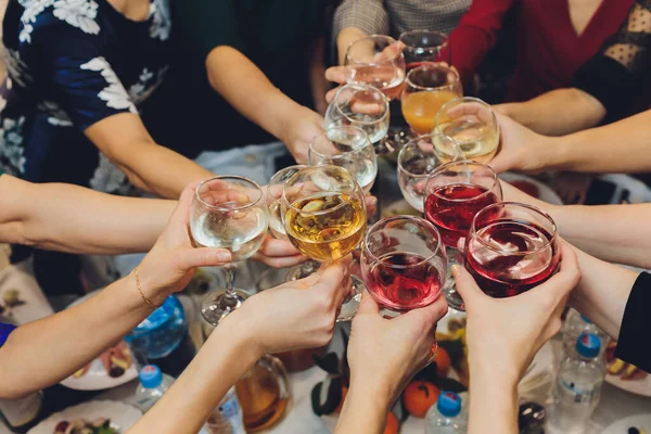 Primer plano del grupo de personas tintineando copas con vino o champán en frente de fondo bokeh. personas mayores manos. — Foto de Stock