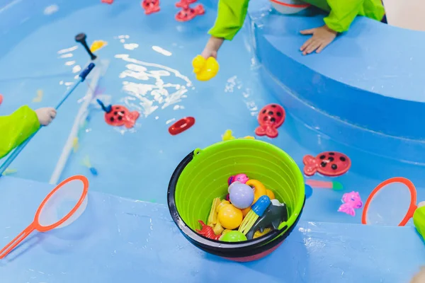 Pesca en la piscina infantil. Juguetes infantiles en la piscina. Caña de pescar de juguete. Alegre pesca infantil, pesca en la piscina infantil. —  Fotos de Stock
