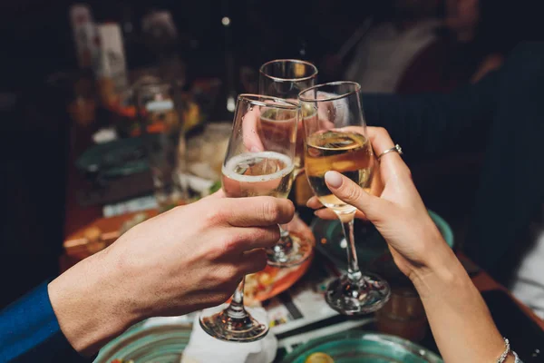 Primer plano del grupo de personas tintineando copas con vino o champán en frente de fondo bokeh. personas mayores manos. — Foto de Stock