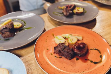 Beyaz tabak sığır filetosu, kök sebze, vişne badem..