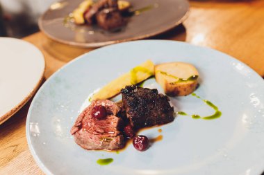 Beyaz tabak sığır filetosu, kök sebze, vişne badem..