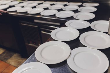 Masada bir sürü beyaz seramik porselen kap tabağı var. Çömlek arkaplanı.