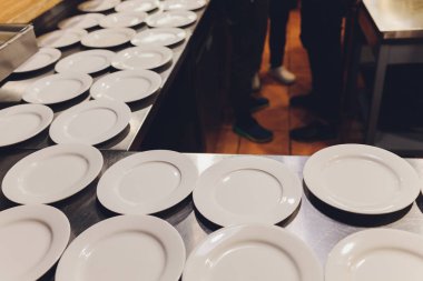 Masada bir sürü beyaz seramik porselen kap tabağı var. Çömlek arkaplanı.