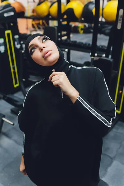 Musulmán asiático mujer en hijab ejercitando en un gimnasio . — Foto de Stock