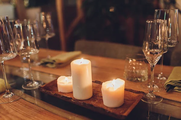 Романтический бокал вина с горящими свечами и бокалы вина на столе в темноте . — стоковое фото