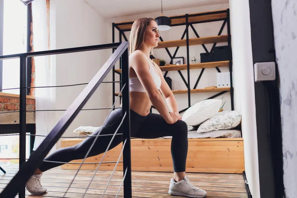 Atractivo fitness mujer haciendo ejercicios de estiramiento en casa, como parte de un estilo de vida saludable sin ir al gimnasio . — Foto de Stock