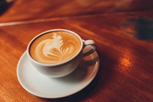 Hot milk art coffee on wooden table. — Stock Photo, Image